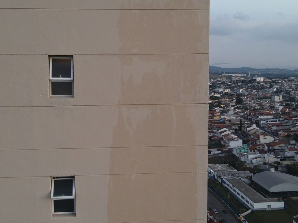 Fachada de prédio fotografada com drone mostrando manchas de umidade