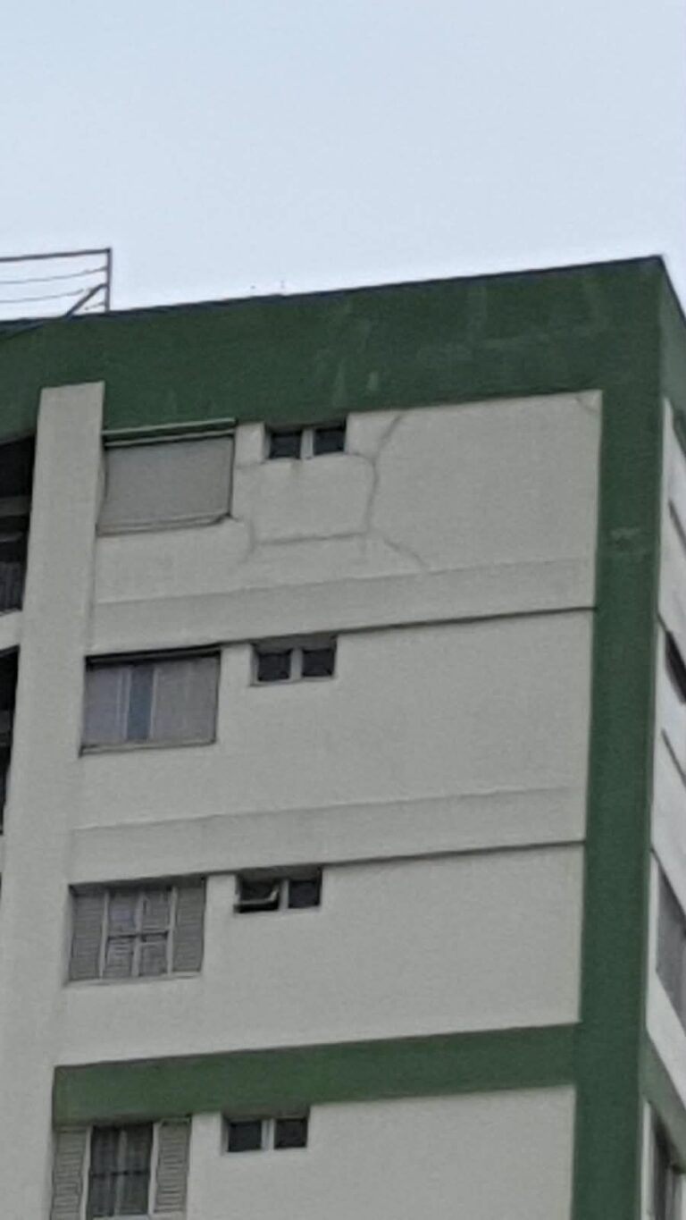 Fachada de prédio com trincas no último pavimento, próximas à platibanda