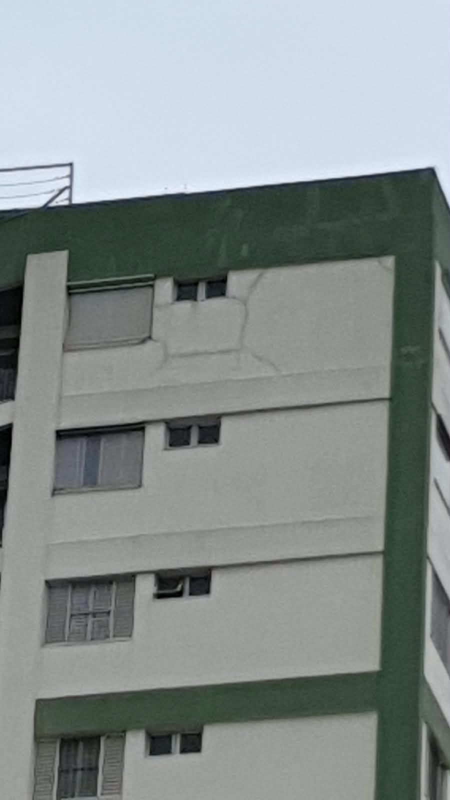 Fachada de prédio com trincas no último pavimento, próximas à platibanda