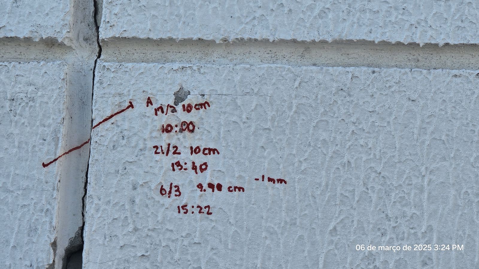 Fissura em fachada com marcação e registro das medições de abertura ao longo do tempo