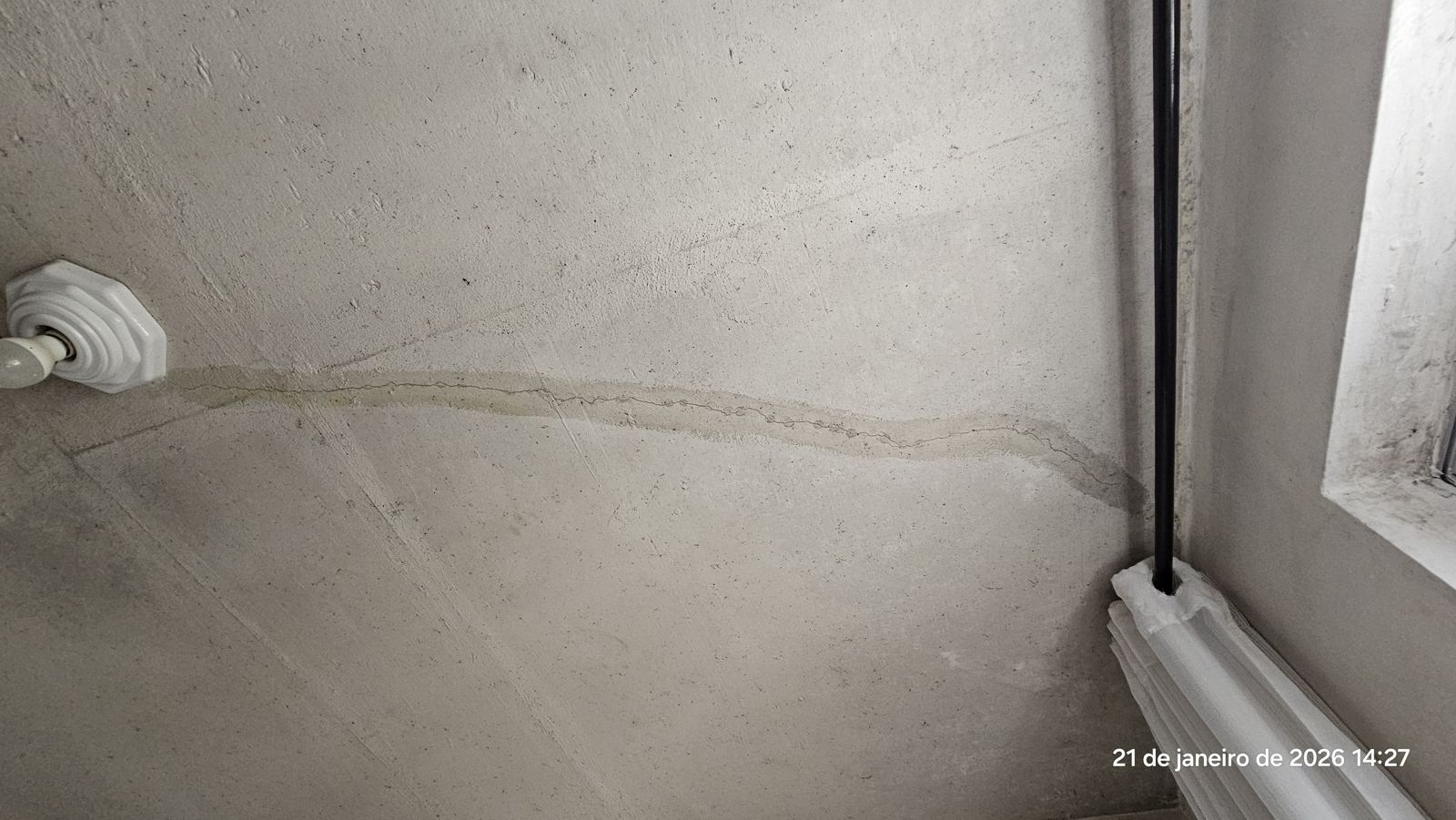 Fissura na laje do teto com marca de umidade ao longo da trinca