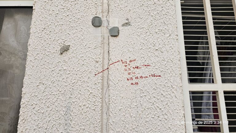 Trinca em fachada monitorada com selo de vidro e registro de medições da abertura